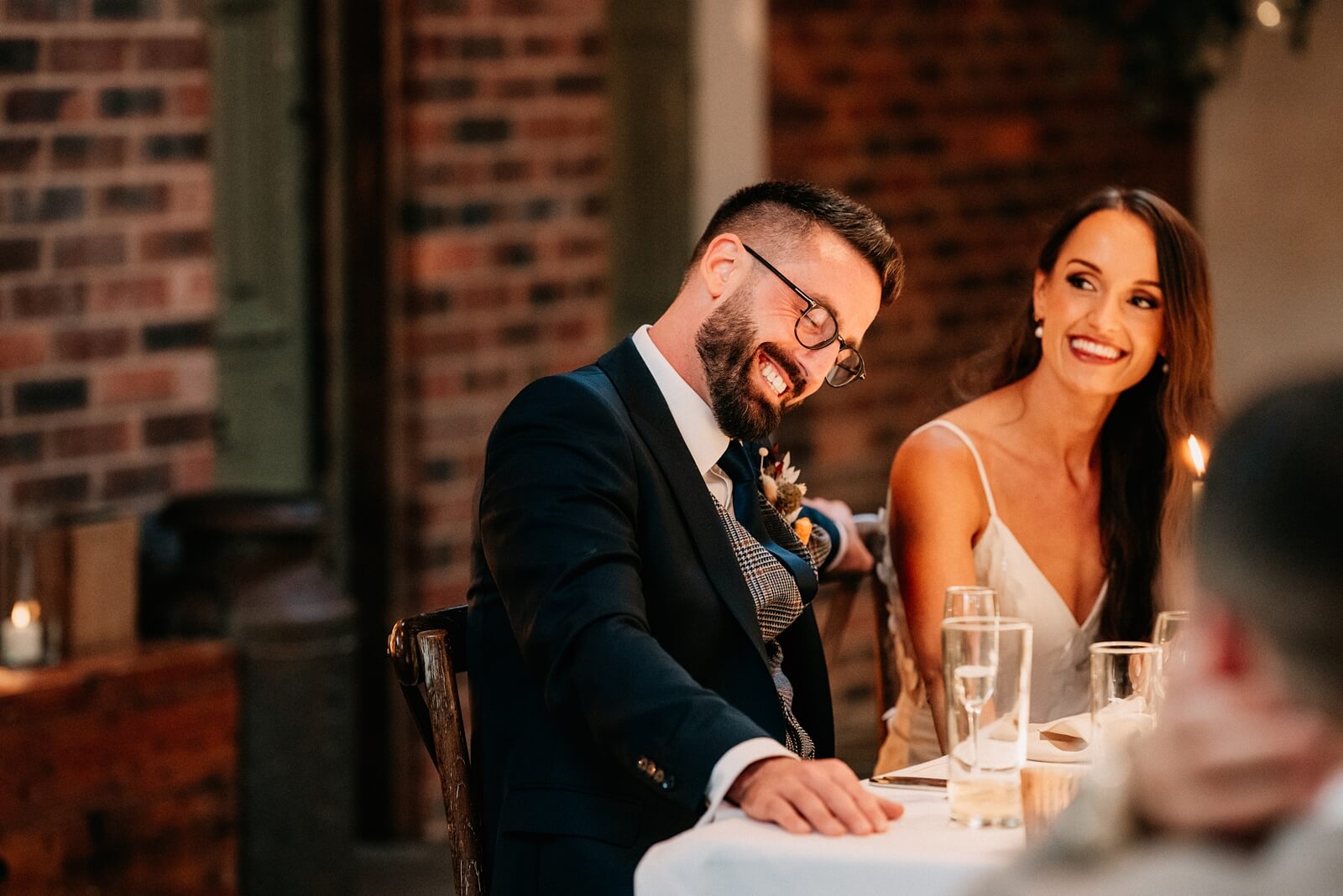 Groom laughing during the best man's speech