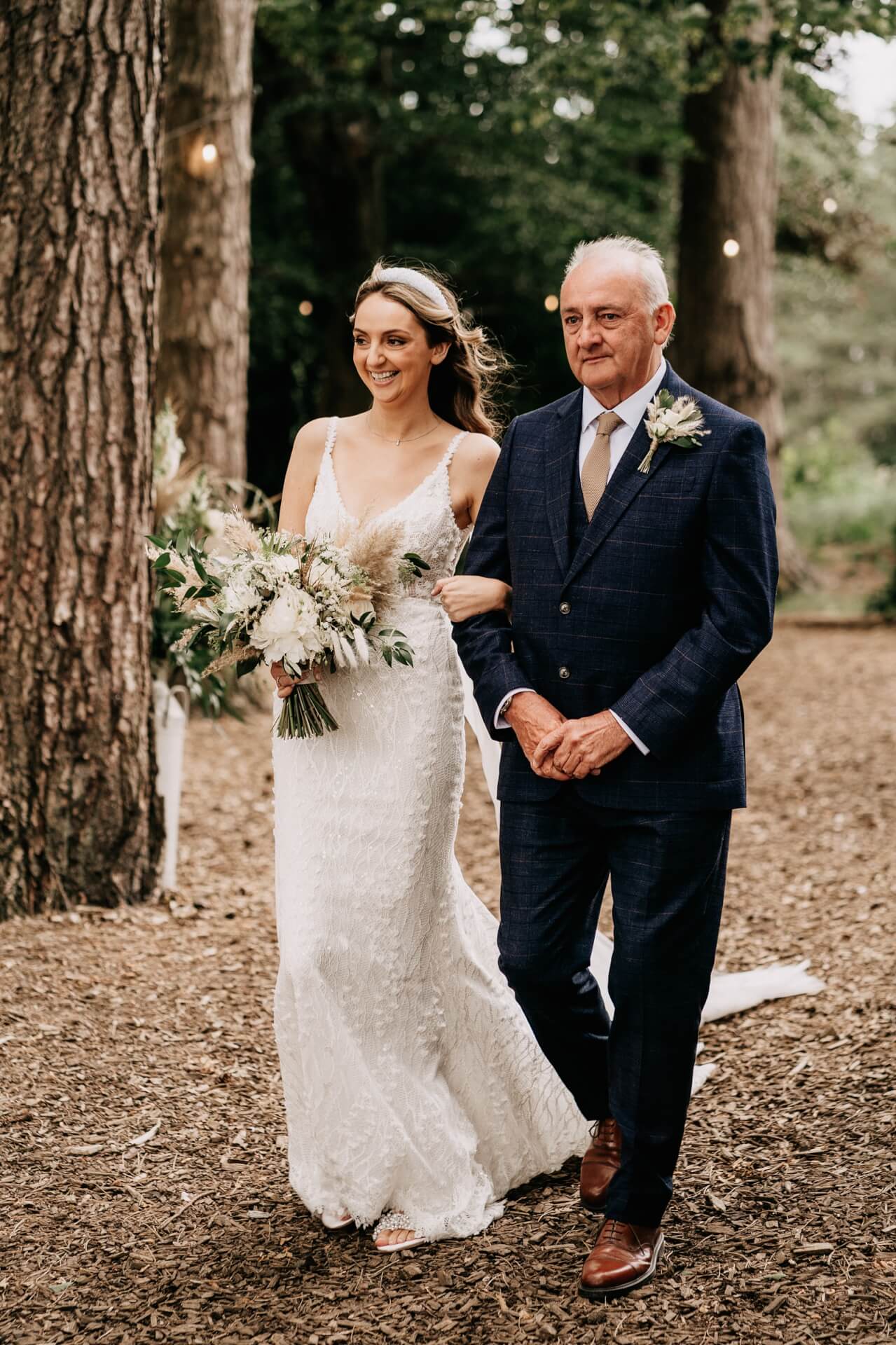 Bride walking down the aisle at woodland ceremony
