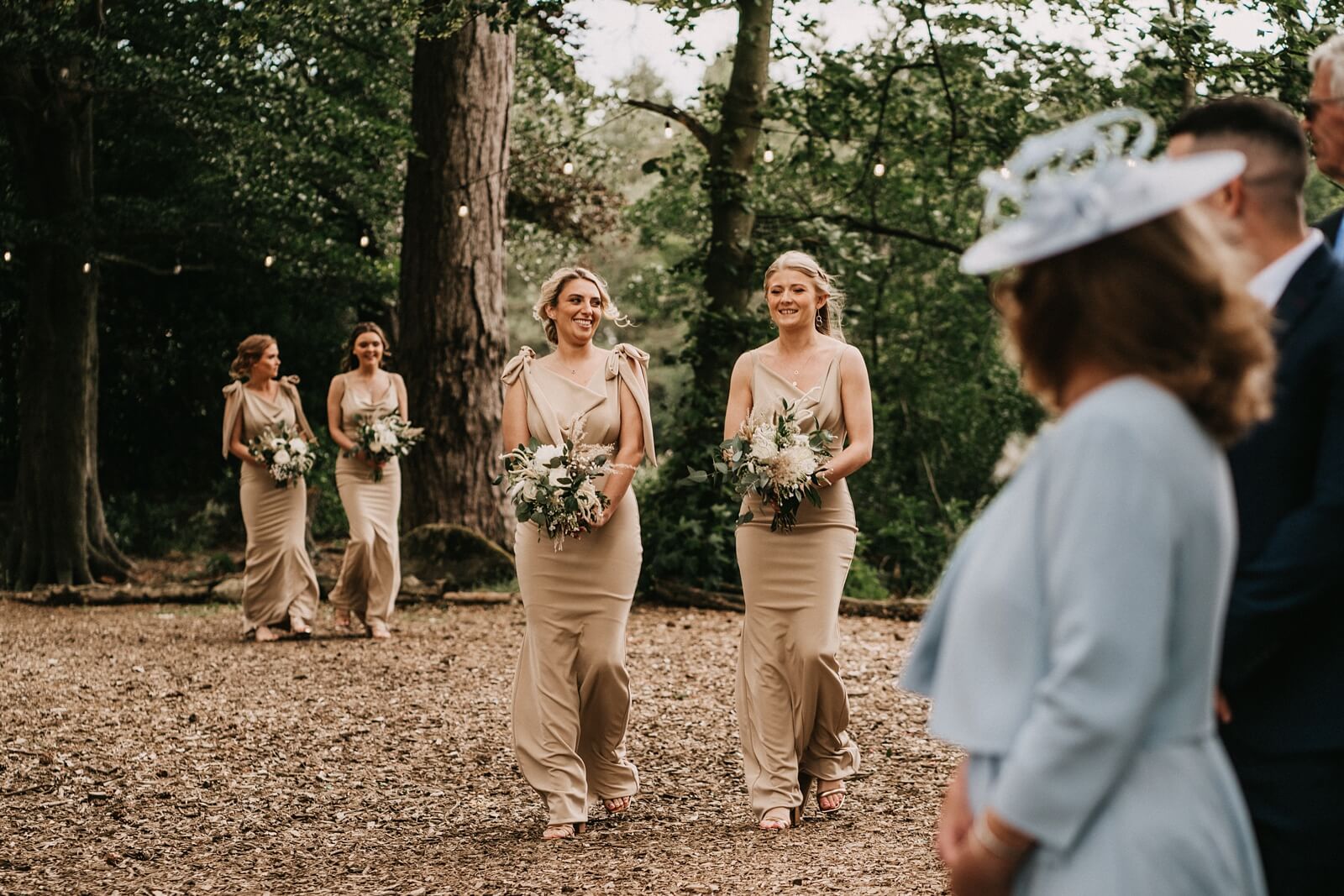 Bridesmaids walking down the aisle at the woodland wedding