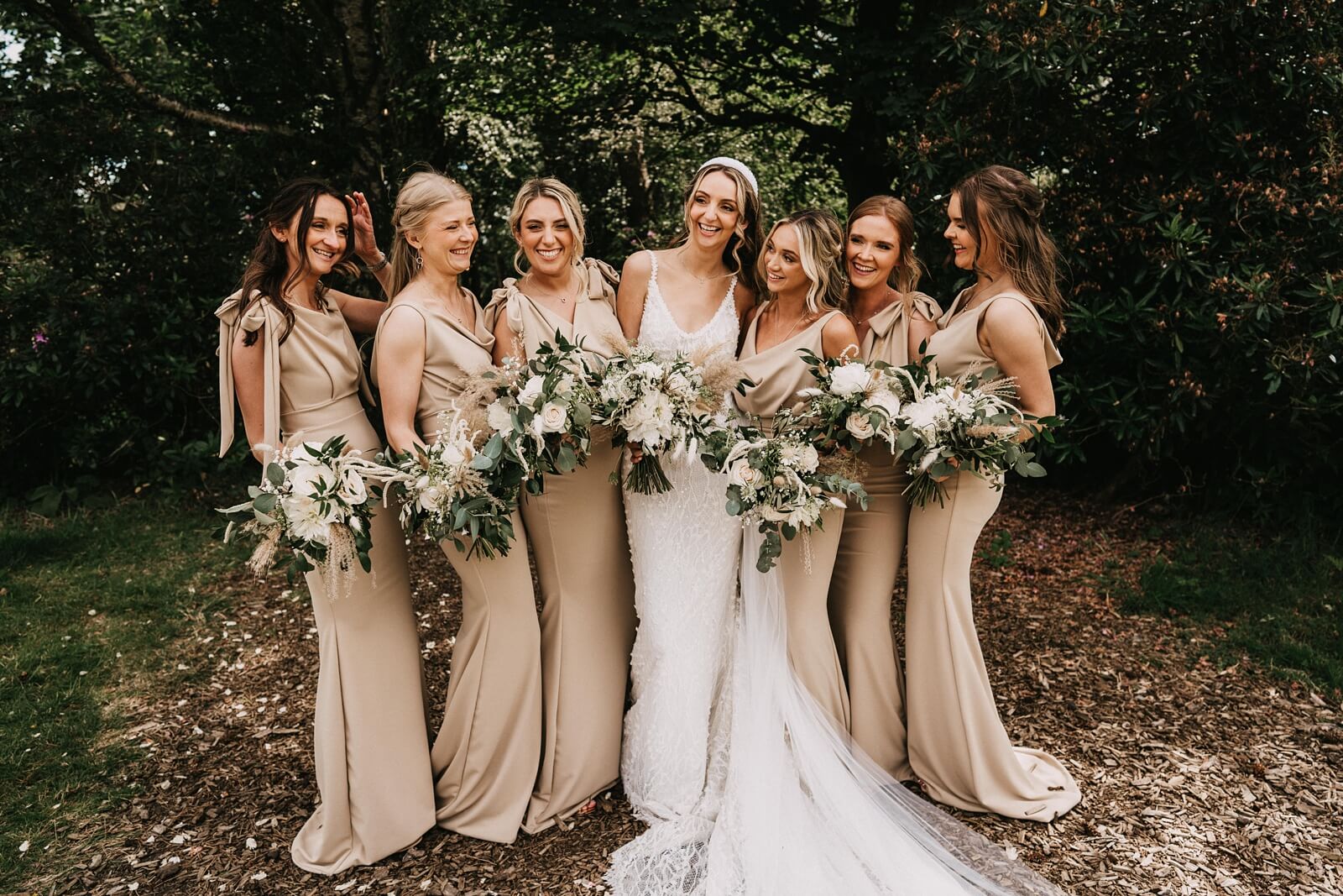 Bride with her bridesmaids with white floral bouquets